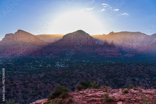 Dramatic sun halo glowing behind silhouetted red rock mountains in Sedona Arizona