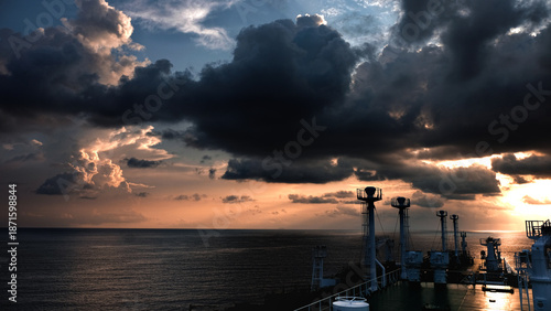 Photos Dramatic storm clouds over open sea viewed from ship deck at sunset