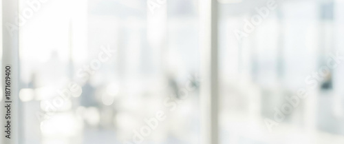 Bright and modern office interior filled with natural light. Blurred figures can be seen engaged in discussion or work, creating a dynamic and collaborative atmosphere.