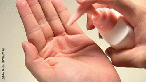 A person using various skincare products, serums, and lotions
