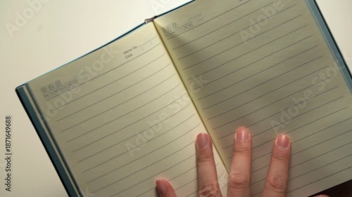 A person is flipping through a notebook