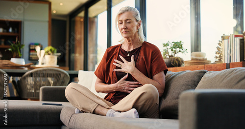 Billede på lærred Breathing, meditation and senior woman on sofa in home with balance, calm or zen practice in living room