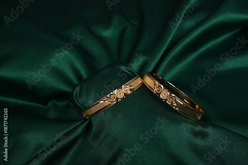 Luxury Gold Bangles on Green Fabric Elegant Jewellery Background