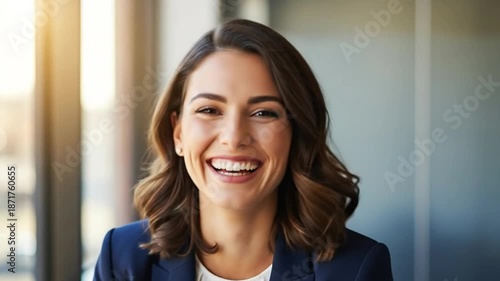 Confident businesswoman laughing happily, smiling directly at the camera.