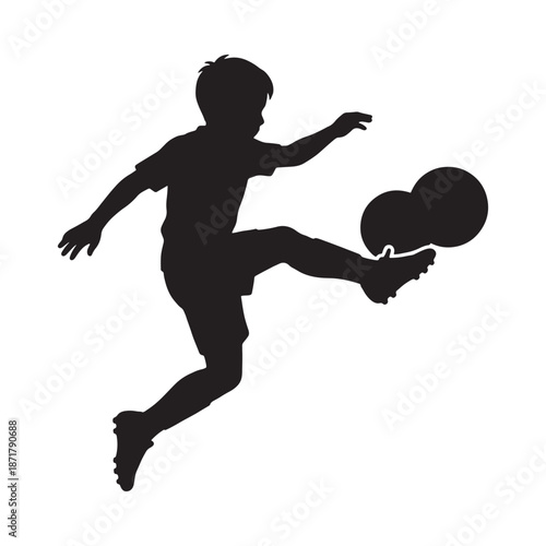 Silhouette of a young boy kicking a soccer ball with energy