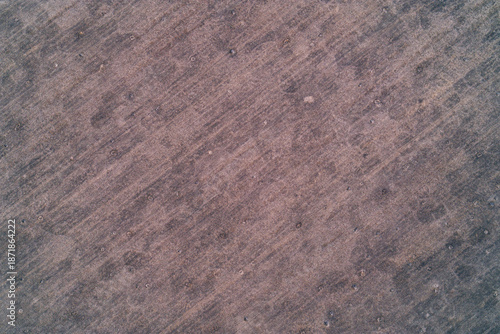 Uneven ground texture with dug holes and dry grass patterns in rural field aerial top down view