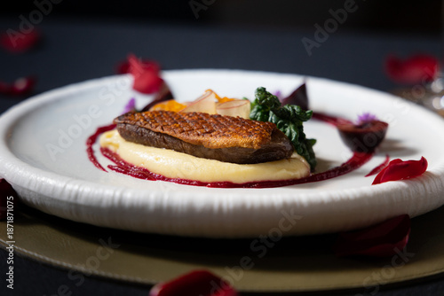 A beautifully plated gourmet meal with a focus on a tenderly cooked duck breast