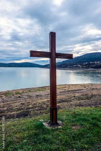 Wooden cross on the lake shore