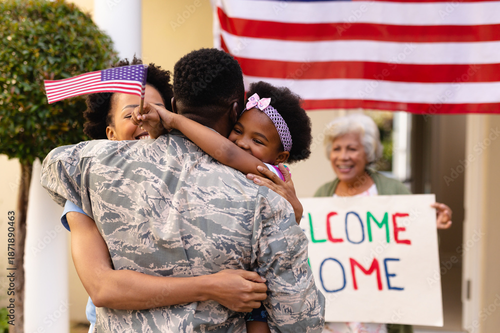 Fototapeta premium African american military soldier embracing woman and daughter at entrance