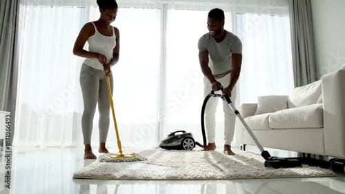 Wallpaper Mural Couple Engaging in Household Chores Together, Cleaning Living Room with Vacuum and Mop in Bright Modern Interior Space Torontodigital.ca