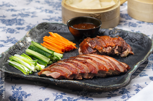 Traditional Peking duck served with cucumber slices, scallions, and hoisin sauce, styled for an elegant feast