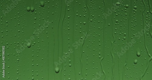 Close up of wet glass with dripping water drops and streaks of rain, on a bright green chroma key background, perfect for visual effects and background replacement. Slow motion.