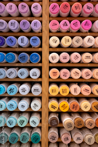 set of alcohol markers in rainbow order in wooden storage