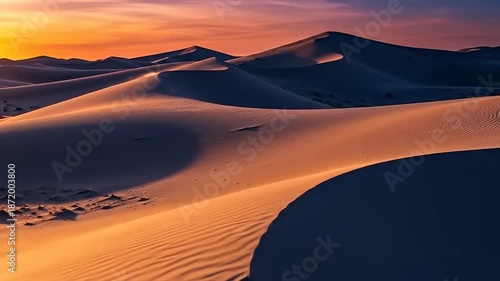 Mesmerizing Sunset Over Vast Desert Dunes with Rippling Sands and Dramatic Shadows.
