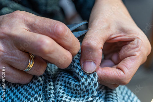 the hands of the seamstress with scissors finishes a job with precision