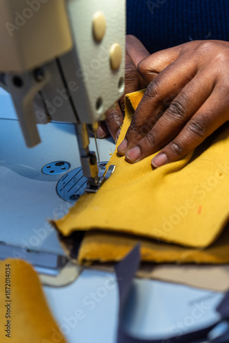 Black woman sews fabric with sewing machine