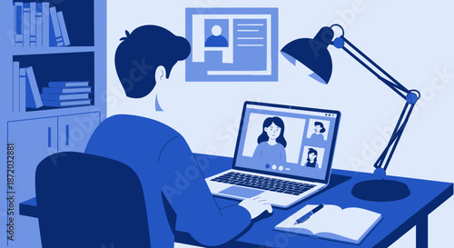 A person attending a virtual meeting at home work from home on a laptop with a desk lamp and books