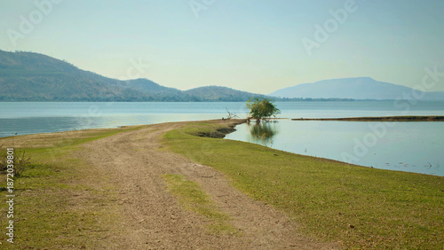 Dirt road leading to the lake with mountains in the background.