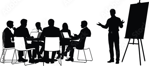 Silhouette of a Business Leader Giving a Presentation to a Team of Professionals Sitting at a Desk with Laptops and Easel