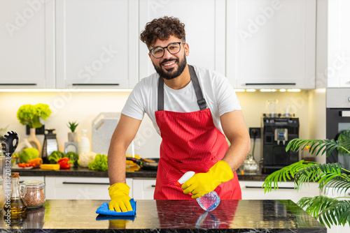 Foto Arabian man wipes kitchen countertop with microfiber cloth removing stains for clean home hygiene and food safety
