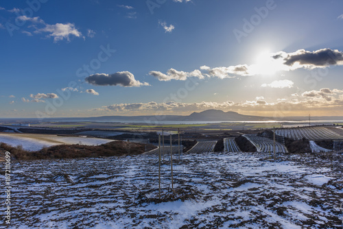 Winter view from Nad Hochberkem of the snowy Palava hills and Nove Mlyny reservoirs. Sunny South Moravian landscape with clouds at sunset