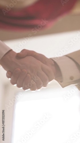 close up of men shaking hands in office