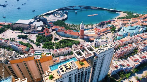 Wallpaper Mural Phu Quoc, Sunset Town, Vietnam. 4k high-quality footage taken with a Drone showcasing colorful buildings, blue skies, a watch tower, a kissing bridge, turquoise clear waters, green forest, golden sand Torontodigital.ca