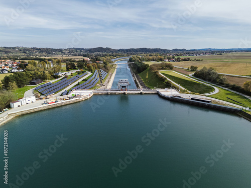 Aerial view of a hydroelectric plant with solar panels, showcasing modern clean energy production for climate action.