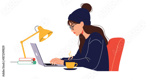 Focused young woman wearing a beanie and glasses working on her laptop late at night with a hot coffee on the desk.