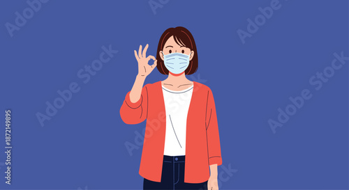 Young woman wearing a medical face mask making an okay hand gesture to signify safety and professional health approval.