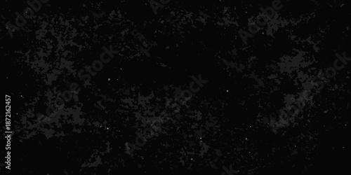 A dark grainy textured background with a scattering of faint bright speckles