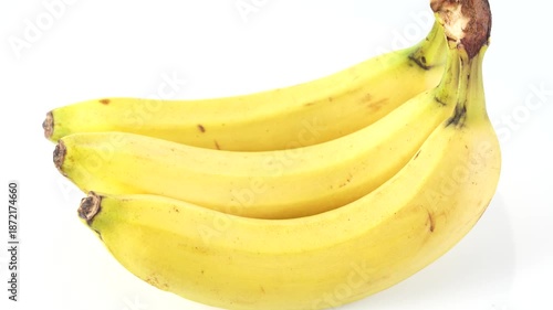 Studio video of bananas rotating smoothly against a clean white background. The spinning motion presents fresh yellow fruit ideal for product showcase, food ads, and nutrition themes.