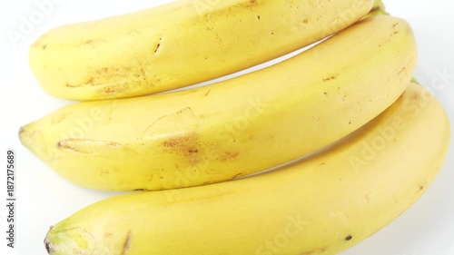 Minimalist video of bananas rotating continuously on a white background. Smooth spinning motion creates a clean food loop perfect for commercials, presentations, and digital media.