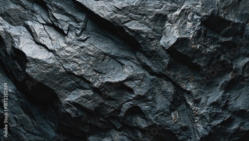 Close-up of rough, dark grey rock texture, detailed and weathered