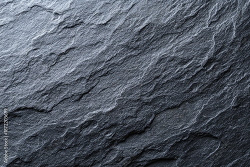 Close-up of rough, textured surface with layered, irregular patterns and shades of gray