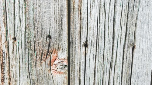 Close-up of weathered wooden planks with a rustic texture. The wood shows signs of aging, with visible grain patterns and natural imperfections.