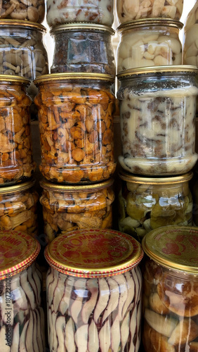 Different types of canned mushrooms in jars on a shelf. Forest, wild mushrooms in the diet.