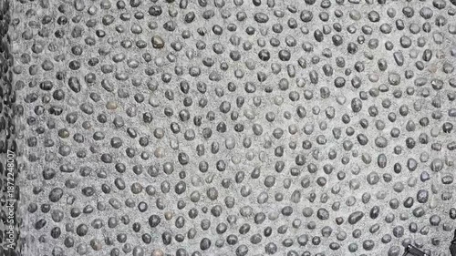 A waterfall flows from above the stone wall. The waterfall curtain is made of artificial fiberglass rocks or small stones, adding a refreshing touch to the atmosphere.Waterfall, stream, natural rocks.