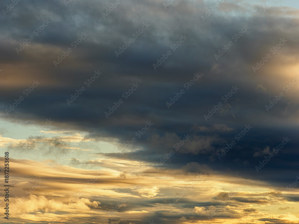 Obraz premium Dramatic dark clouds moving across a golden sky