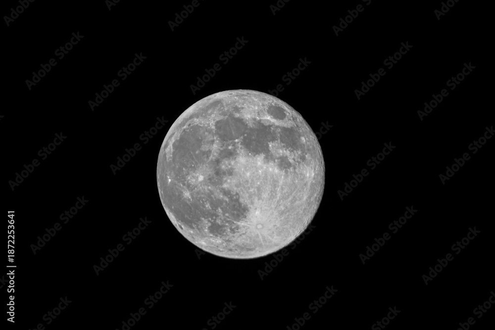 Obraz premium Bright full moon isolated on black night sky with copy space