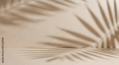 Abstract background with blurred palm leaf shadow on beige wall, creating a soft and natural backdrop for product presentation and tropicalthemed designs
