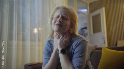 Portrait of ill young woman at home having cough and sore throat. First symptoms of cold and flu virus, pneumonia, bronchitis and respiratory tract infection. Seasonal virus disease.