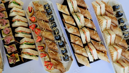 Fotografía Gourmet catering featuring elegant platters with colorful canapes, triangular sa