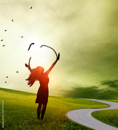 silhoeuute einer Frau mit zerbrochenen Ketten vor einer imaginären lanschaft