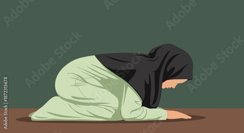Muslim woman in a black hijab and light green dress performing sujud prayer on a brown floor against a dark green wall.