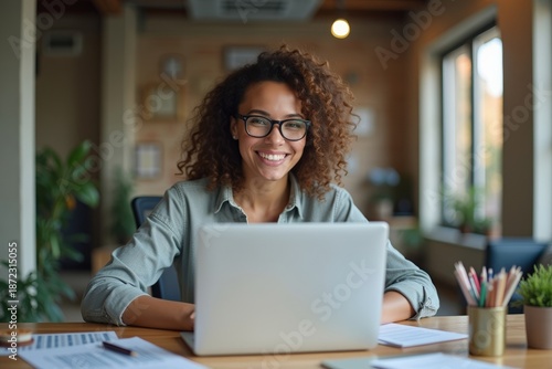 Innovative and Creative Female Social Media Manager Smiling While Crafting a Winning Strategy in Her Office