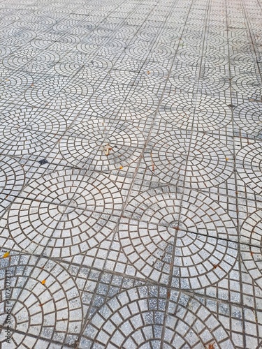 Grey concrete paving slabs with decorative concentric circle design for urban architecture and street infrastructure