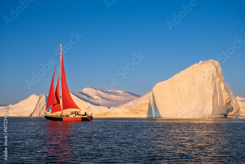 Red Sailboat Cruising Among Giant Icebergs in Disko Bay, Greenland
