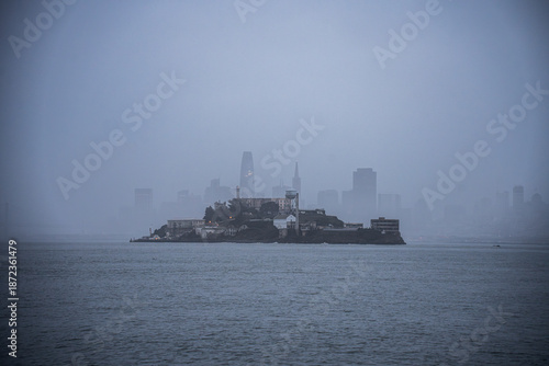 Alcatraz Island Prison in Fog, San Francisco Bay. View from dense fog in San Francisco Bay, with the downtown San Francisco skyline barely visible in the background