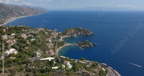 Aerial view of Isola Bella, in Sicily, Italy. It is an Italian coastal island located in the Mediterranean Sea, near Taormina. In the background, the Calabrian coast is visible on the horizon.